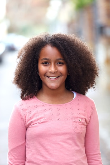 Linda chica afroamericana en la calle con pelo afro