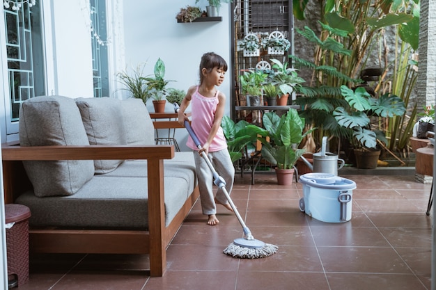 Linda chica asiática ayudando con la limpieza