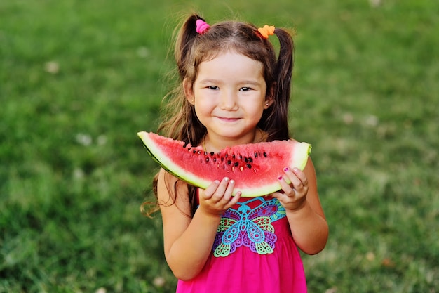 Linda chica asiática comiendo jugosa sandía y sonriendo