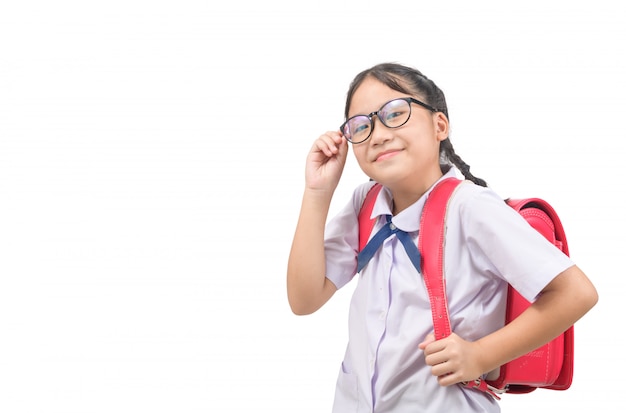 Linda chica asiática estudiante viste uniforme y lleva mochila escolar aislado