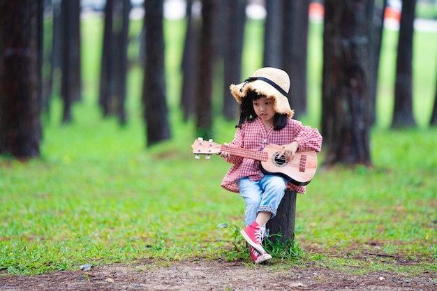 Foto linda chica asiática tocando la guitarra