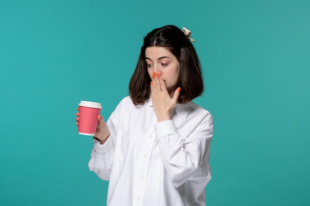 Linda chica bastante morena joven dulce chica en camisa blanca mirando la taza de café