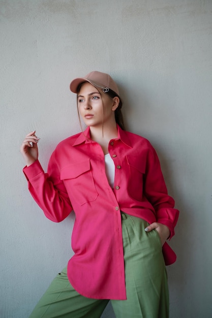 Linda chica con camisa rosa en el muro de hormigón