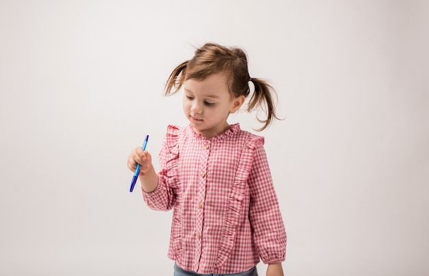 Linda chica con coletas y un asa, una chica en una blusa con un bolígrafo azul