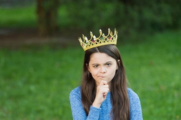 Foto linda chica corona dorada al aire libre verde naturaleza fondo gruñón princesa concepto