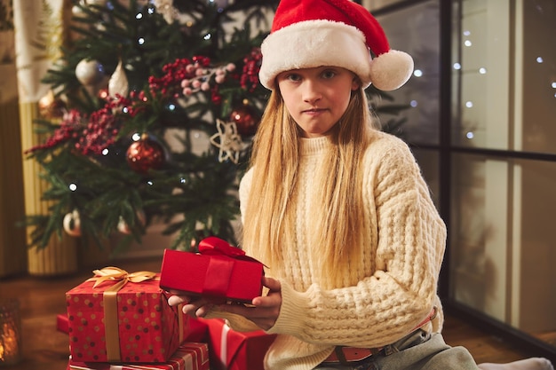 Linda chica curiosa con regalo de Navidad en el interior