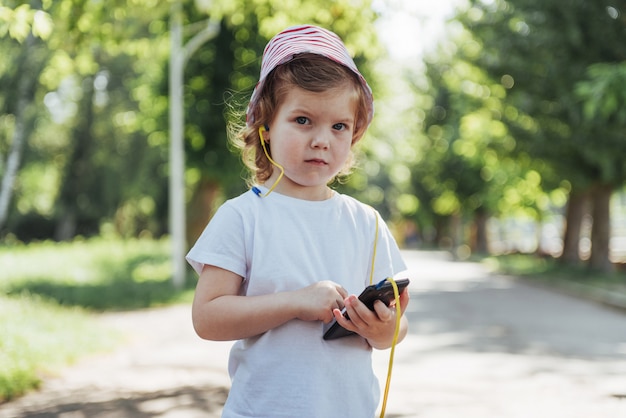 Linda chica escuchando música con auriculares al aire libre