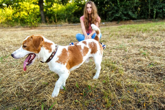 Linda chica está jugando con su perro en el parque