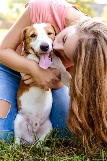 Linda chica está jugando con su perro en el parque