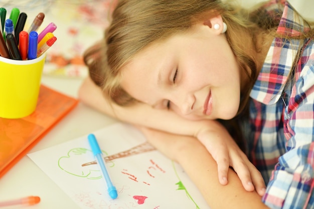 Linda chica estudiante durmiendo durante la clase de arte