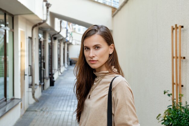 Linda chica frente a la entrada de apartamentos