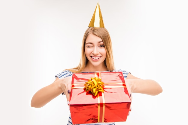 Linda chica en gorro de cumpleaños con presente