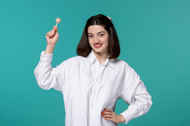 Linda chica guapa morena dulce joven en camisa blanca con la mano en la cintura feliz