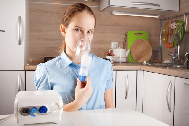 Linda chica haciendo inhalación en la cocina