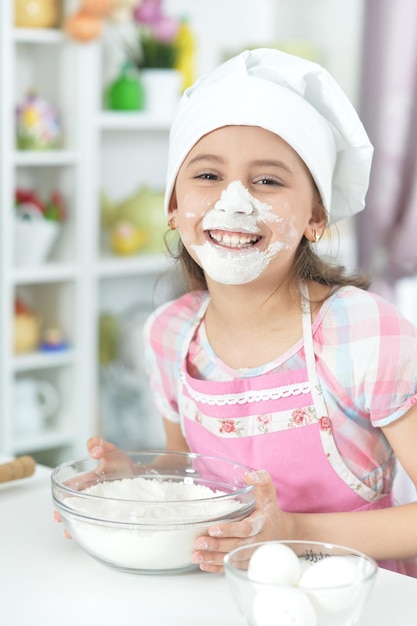 Linda chica horneando en la cocina en casa