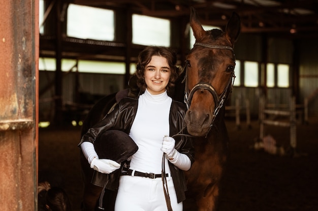 Foto linda chica jinete junto al hermoso caballo marrón tiro primer plano hermosa joven se encuentra junto a ...