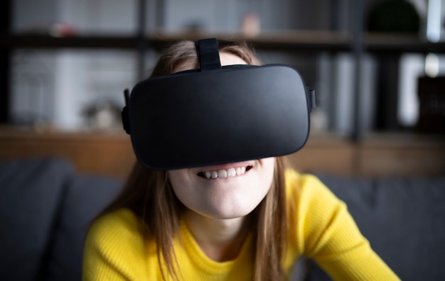 Linda chica juega en la consola. Mujer joven feliz con un casco de realidad virtual