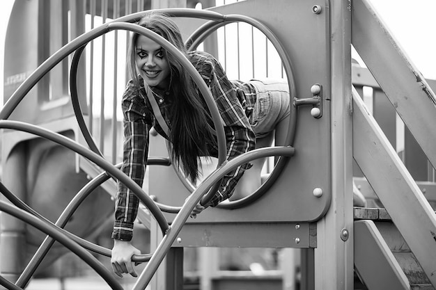 Linda chica en un maquillaje de payaso en una foto de fondo en blanco y negro