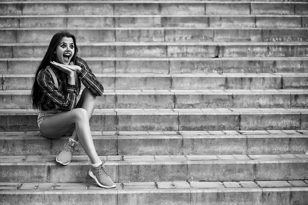 Linda chica en un maquillaje de payaso en una foto de fondo en blanco y negro