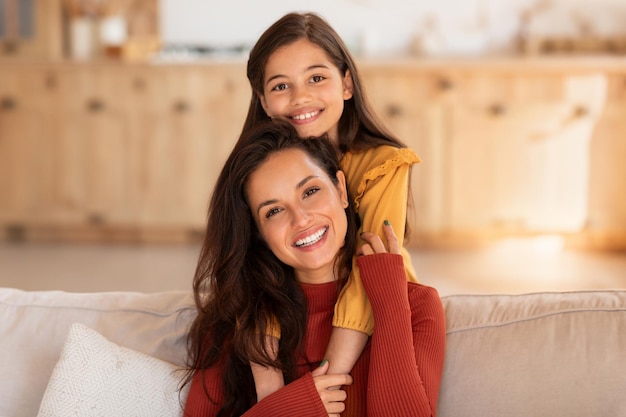 Linda chica del Medio Oriente abrazando a mamá desde casa