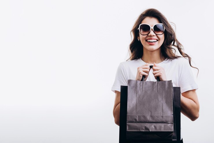 Linda chica morena de compras posando con bolsas de papel