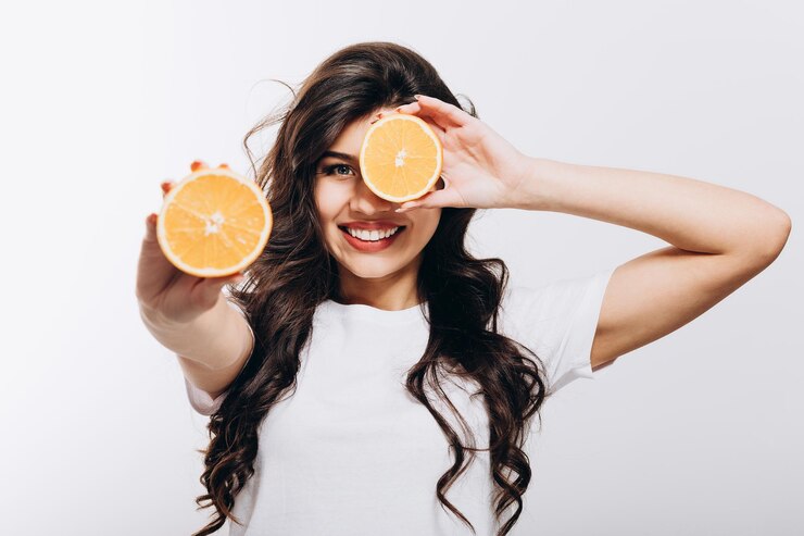 Linda chica morena con mitades de cítricos