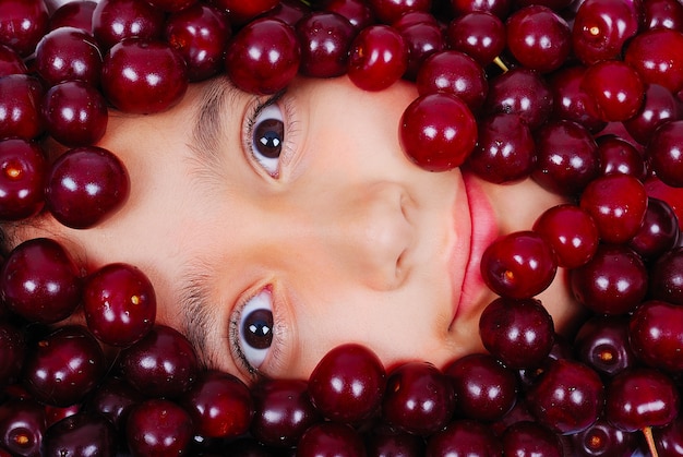 Foto una linda chica bajo muchos pedazos de cereza