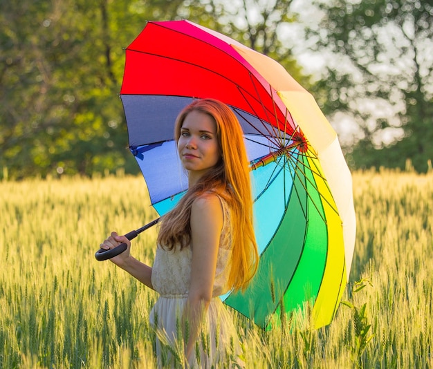 Linda chica con un paraguas multicolor