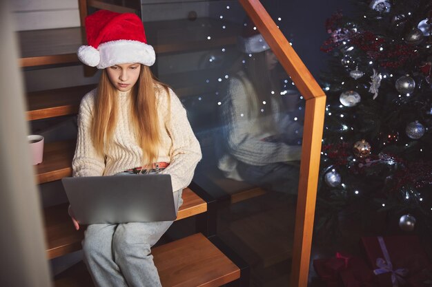Linda chica pasando la Navidad con una laptop en casa