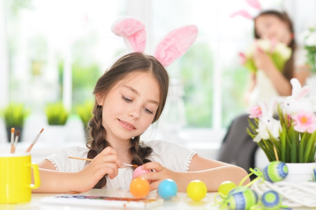 Linda chica pintando huevos para Semana Santa