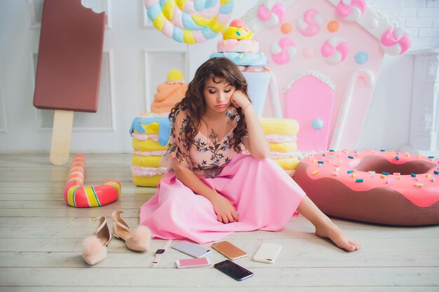 Linda chica posando con rosquillas rosas, jugando, postre, mala comida, mira el agujero en la rosquilla, mantiene las rosquillas a los ojos