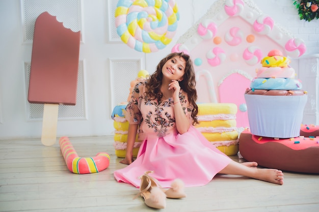 Linda chica posando con rosquillas rosas, jugando, postre, mala comida, mira el agujero en la rosquilla, mantiene las rosquillas a los ojos