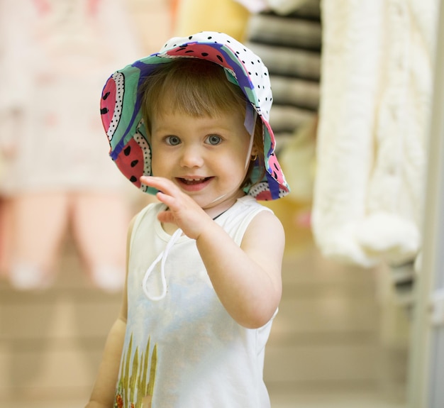 Linda chica se prueba colorido sombrero en la tienda de niños, teleobjetivo