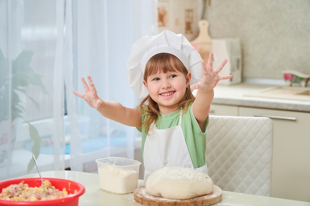 Linda chica riendo cocina agitando sus manos