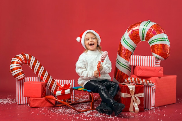 Foto linda chica rodeada de elementos y regalos de navidad