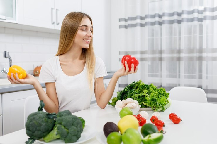 Linda chica rubia eligiendo qué pimiento comer
