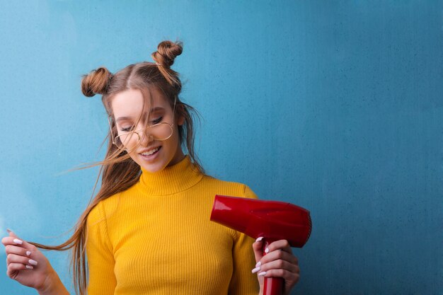 Linda chica con un secador de pelo