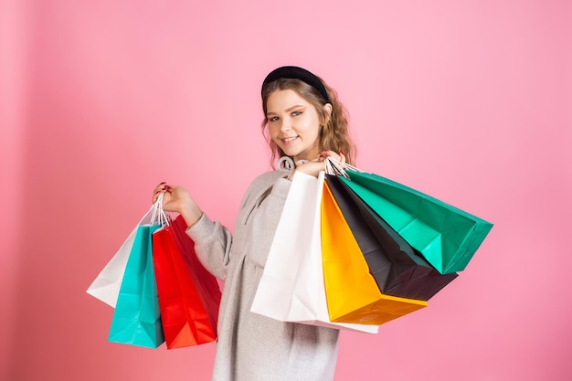 Linda chica sosteniendo bolsas de papel brillante