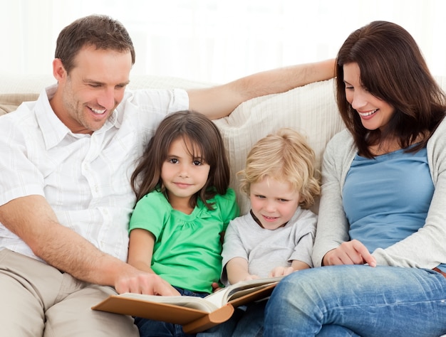 Linda chica y su familia mirando un álbum de fotos