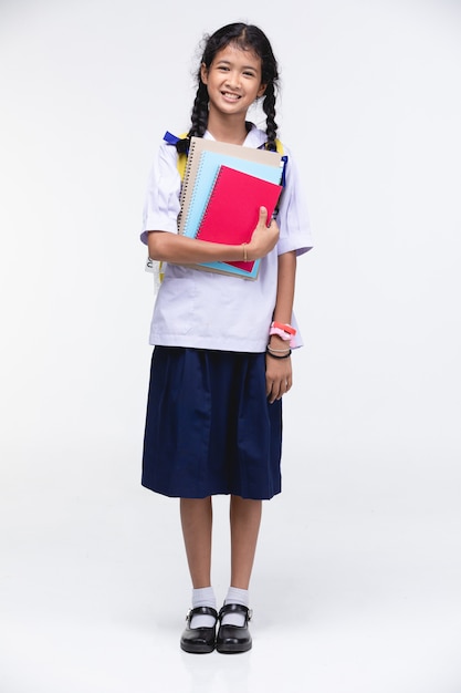 Linda chica en uniforme de estudiante con papelería en gris