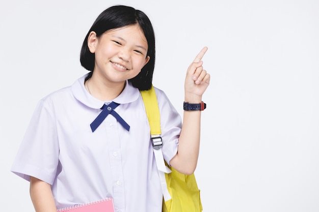 Linda chica en uniforme de estudiante con papelería en gris