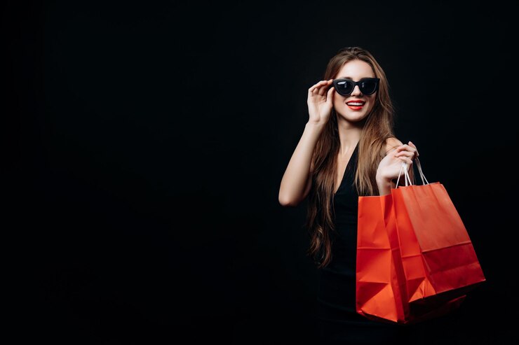 Linda clienta boutique femenina con bolsas de compras de moda