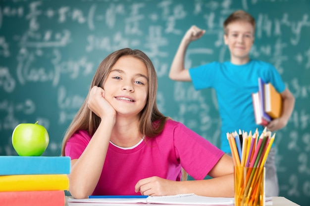 Linda colegiala feliz y colegial en el aula