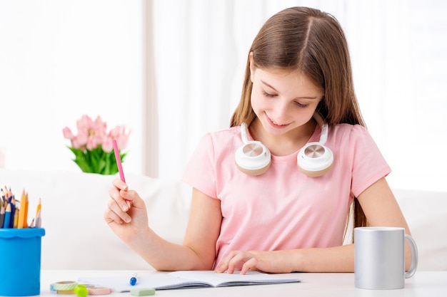 Linda colegiala haciendo la tarea en casa