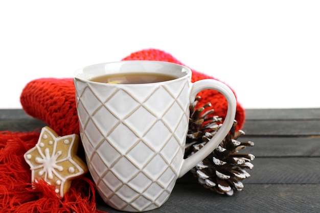 Linda composição de inverno com xícara de bebida quente na mesa de madeira com fundo branco