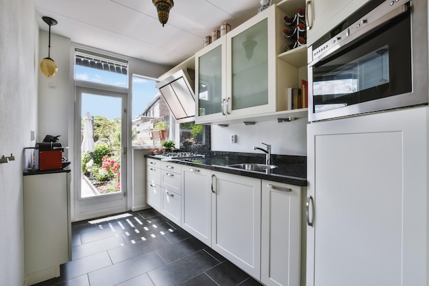 Foto linda cozinha estreita e longa com piso preto e conjunto de cozinha branco