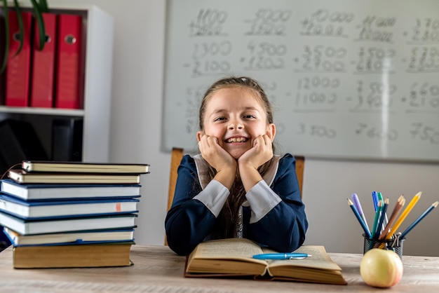 Linda criança está se preparando para responder em uma lição na escola