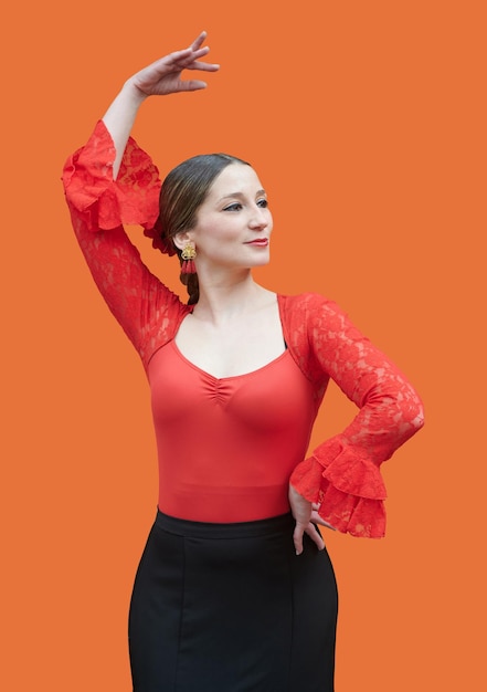 Linda dançarina de flamenco com gesto clássico em fundo laranja Posando conceito