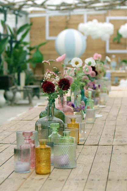 Linda decoração com flores e vasos de vidro coloridos