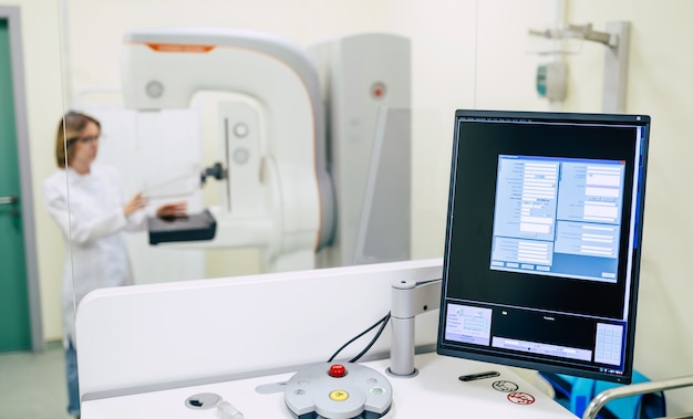 Linda doctora profesional está trabajando con una moderna máquina de sistema de rayos X de mamografía en un hospital o clínica privada.